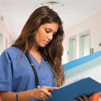 Portrait of a young nurse reading a document in an hospital