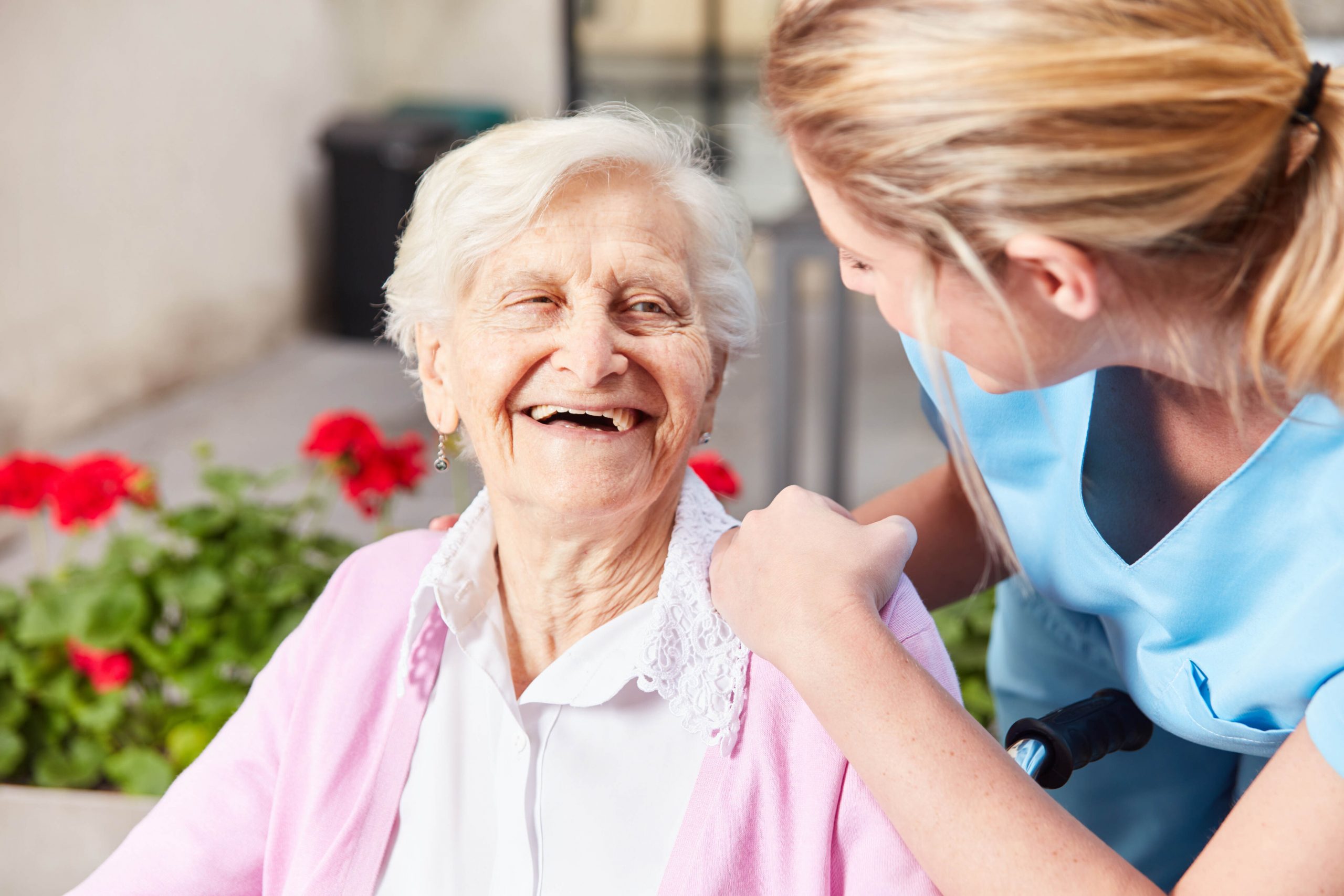 Lachende oudere vrouw spreekt met verpleegkundige