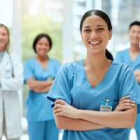 Verpleegkundige met andere zorgmedewerkers op de achtergrond